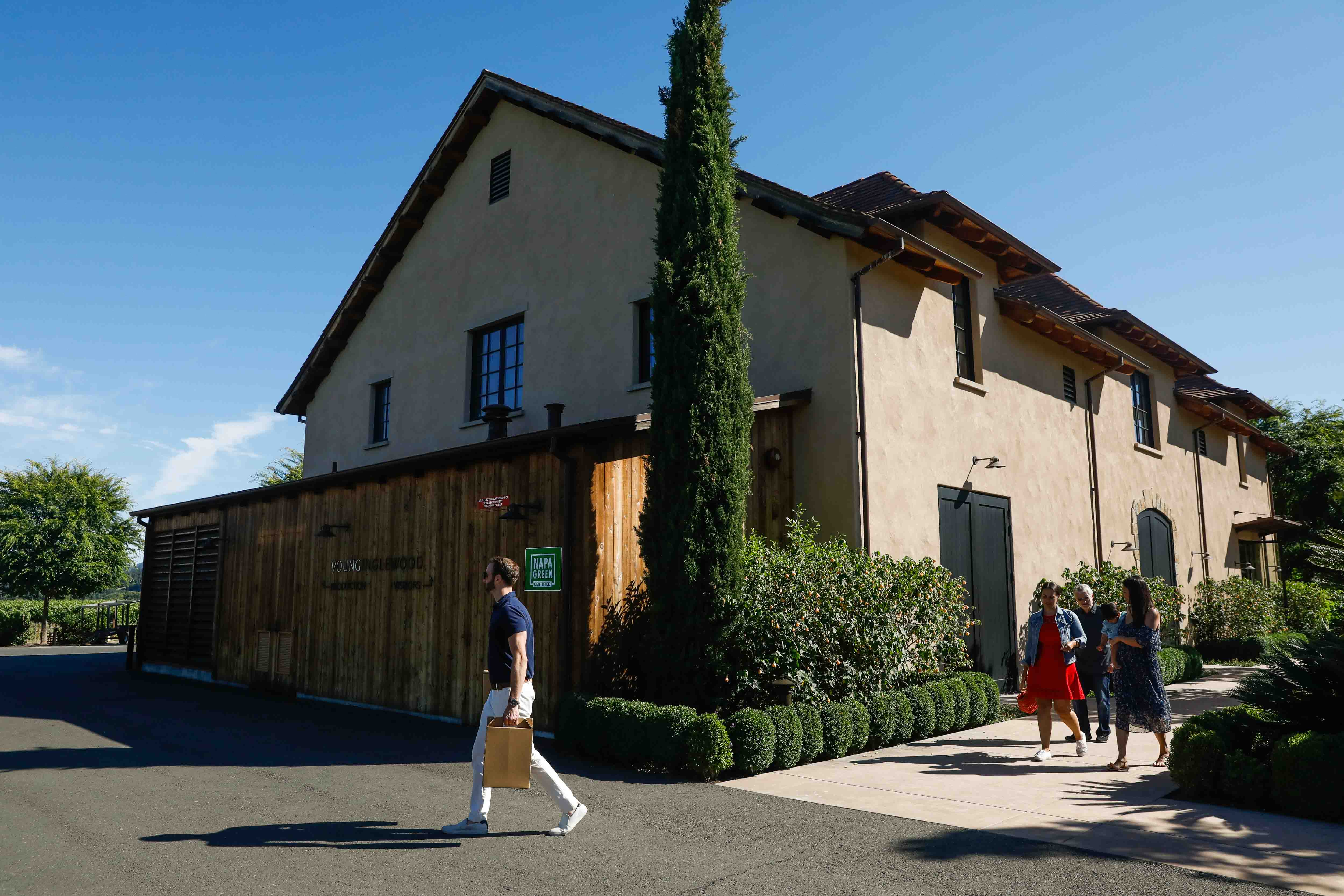 Taking home a piece of Young Inglewood. Photo of Beautiful blue sky behind Young Inglewood's winery with customers carrying wine out to their car after a delicious tasting.